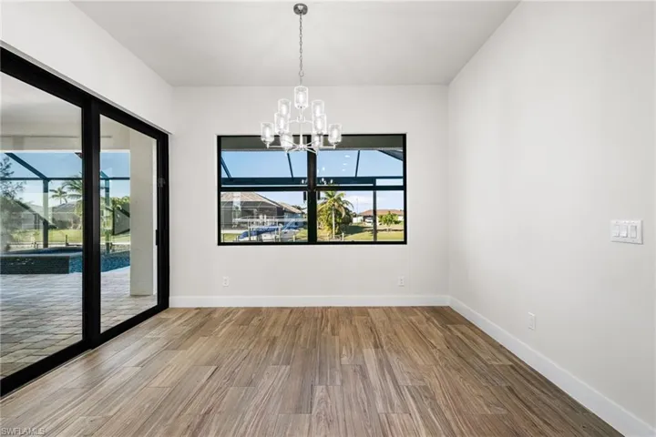 Unfurnished room featuring wood-type flooring and a notable chandelier