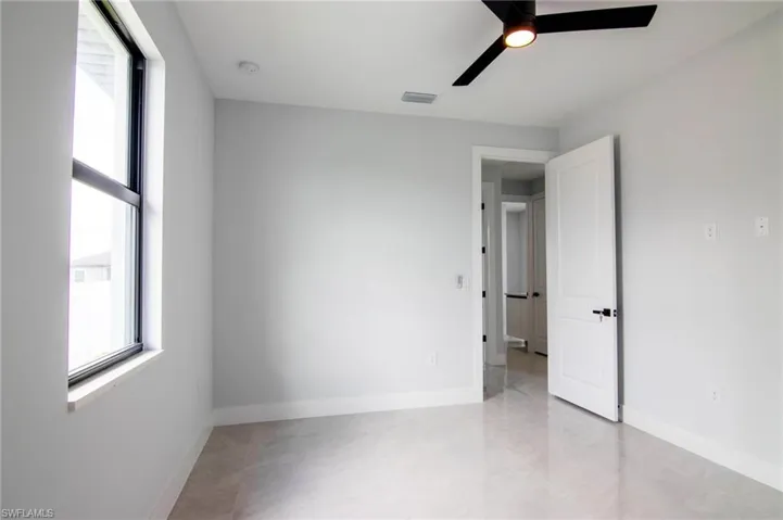 Spare room featuring plenty of natural light and ceiling fan