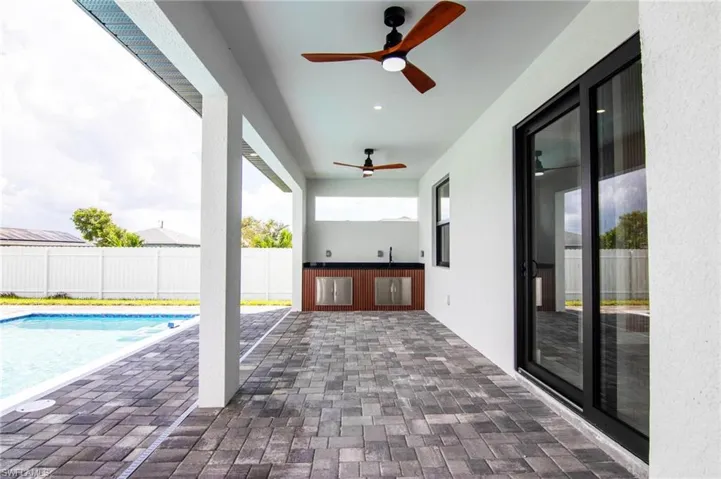 View of swimming pool with ceiling fan and a patio