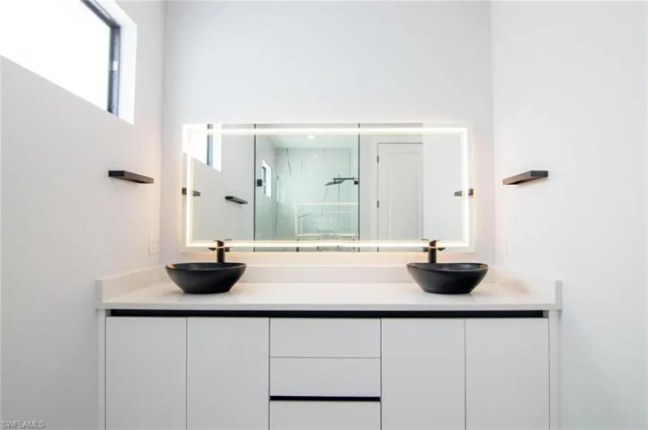 Bathroom featuring an enclosed shower and vanity