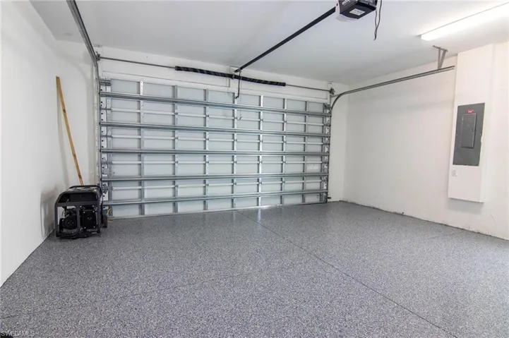 Garage featuring a garage door opener and electric panel