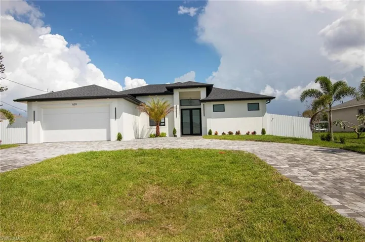 View of front of house with a garage and a front yard