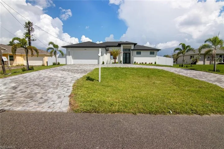 View of front of house with a front yard and a garage