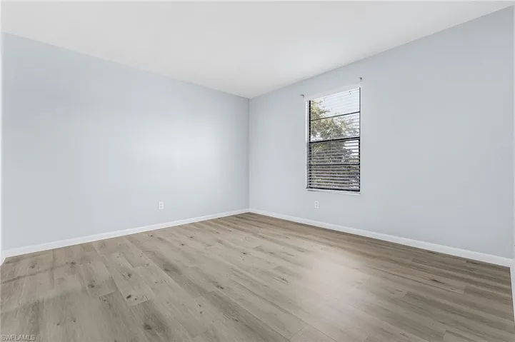 Interior room featuring light blue walls and wood-finish flooring