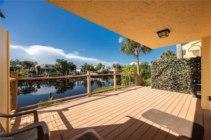 Wooden terrace featuring a boat dock and a water view