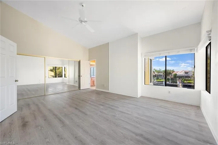 Unfurnished bedroom with high vaulted ceiling, ceiling fan, light hardwood / wood-style floors, and a closet