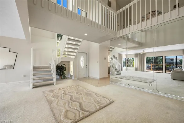 Carpeted entryway with a towering ceiling