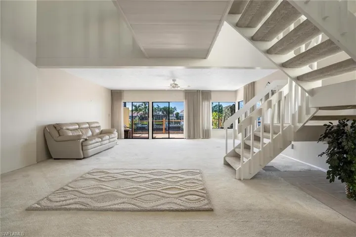 Staircase with carpet floors and ceiling fan