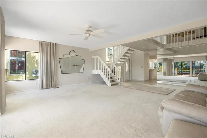 Unfurnished living room with ceiling fan and light colored carpet