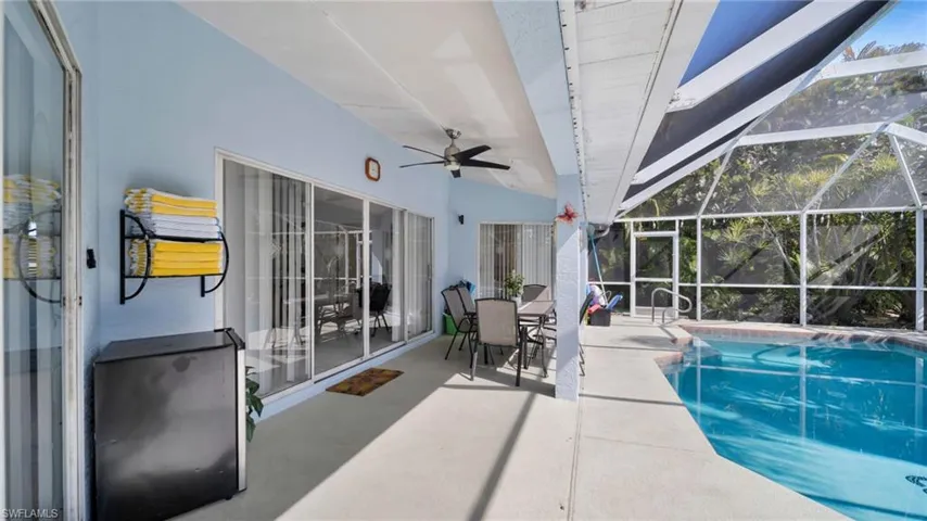 Screened lanai featuring a swimming pool, concrete decking, and multiple sliding glass doors