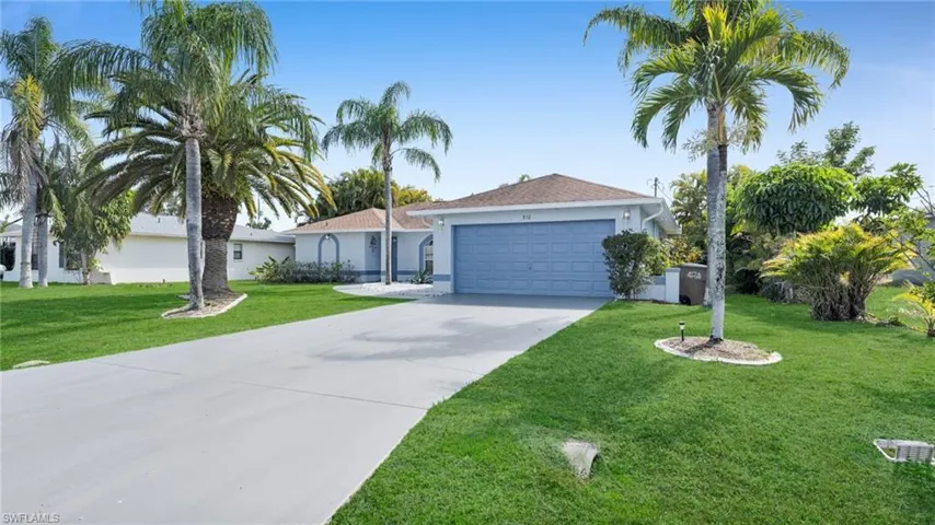 Single-story residence featuring a two-car garage and a paved driveway