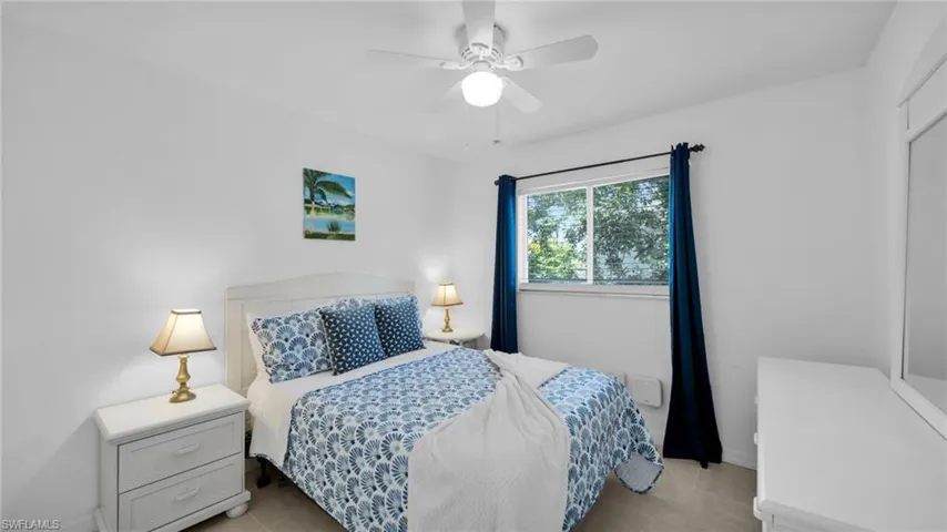 Bedroom featuring light-colored walls and a window with a garden outlook