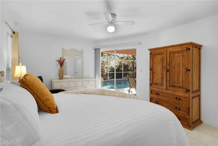 Bedroom with access to outside, light tile patterned flooring, and ceiling fan
