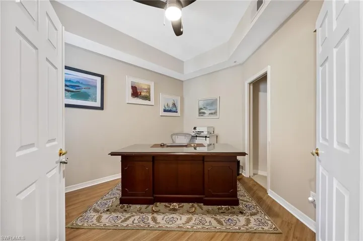 Home office with ceiling fan and light wood-style flooring