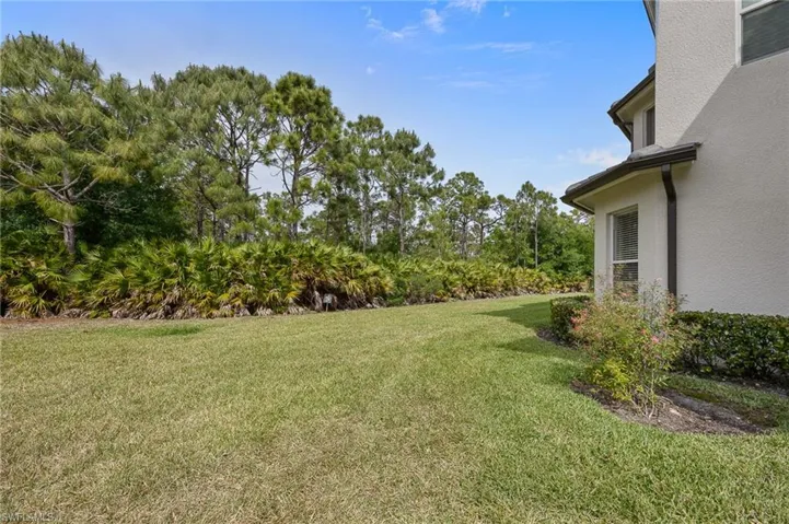 View of green lawn featuring view of scattered trees