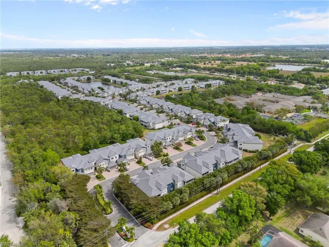 Aerial view of property and surrounding area with nearby suburban area and a nearby body of water