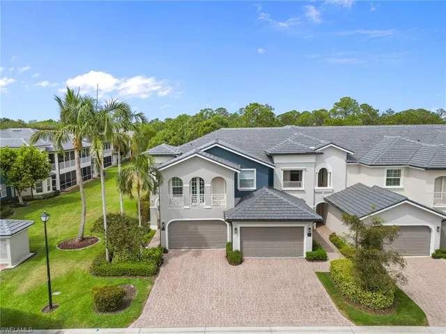 View of front of house featuring stucco siding, decorative driveway, a front lawn, and a tiled roof