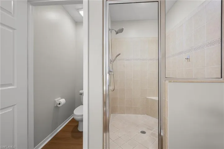 Bathroom with a shower stall and light wood-style floors