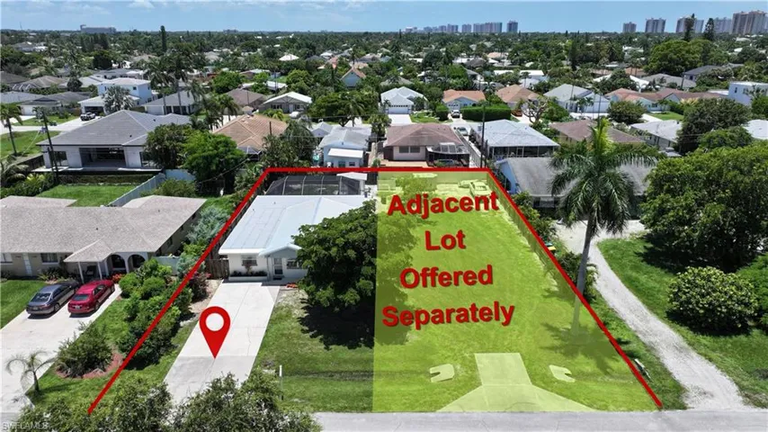 Single-story residence featuring a paved driveway, mature landscaping, and a screened rear patio