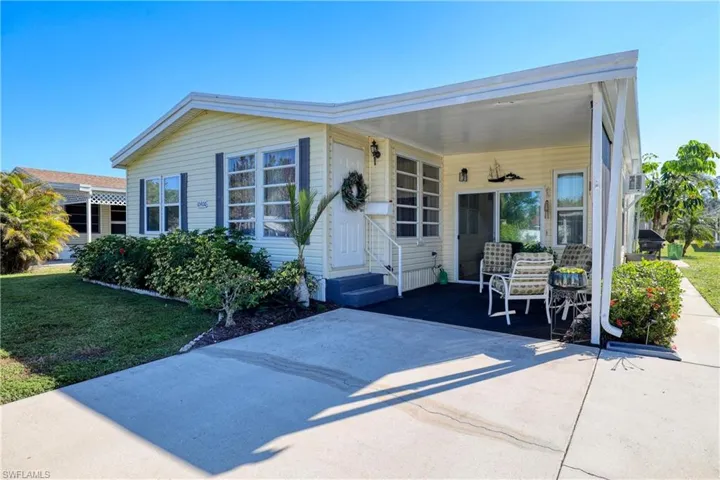 View of front of property featuring a carport and a front lawn