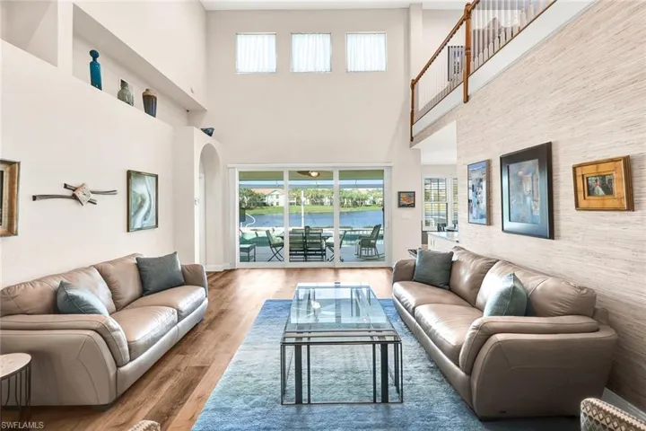 Living room with hardwood / wood-style floors and a towering ceiling