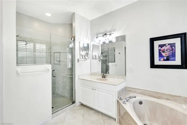 Bathroom with tile patterned flooring, vanity, and independent shower and bath