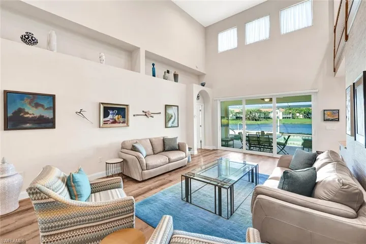 Living room with light hardwood / wood-style flooring and a high ceiling