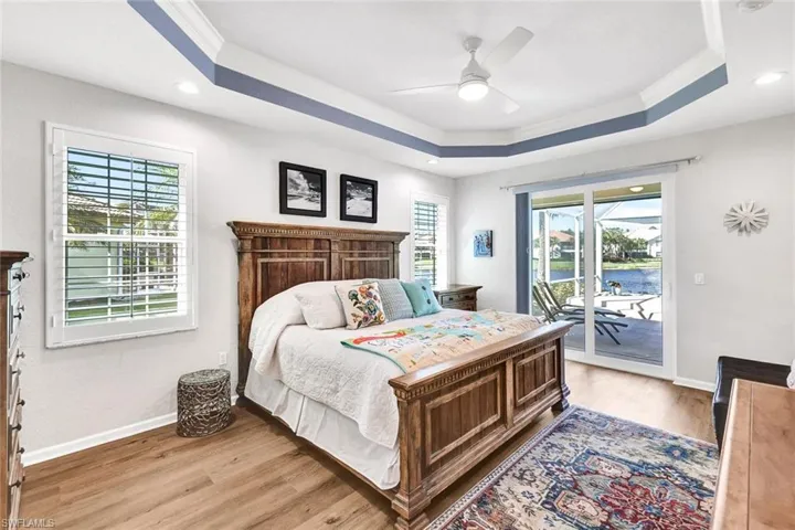 Bedroom featuring access to outside, multiple windows, ceiling fan, and light hardwood / wood-style flooring