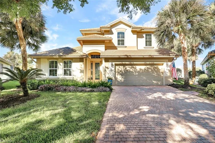 Mediterranean / spanish-style house featuring a garage and a front lawn