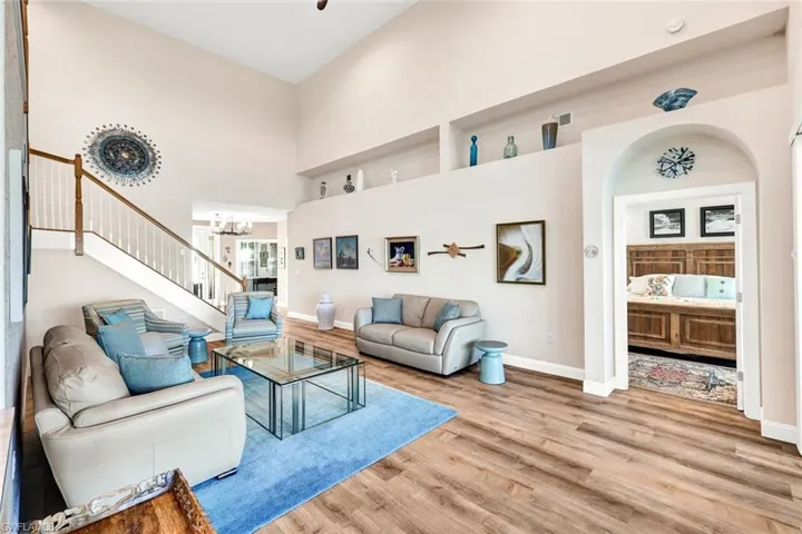 Living room featuring light hardwood / wood-style floors, a towering ceiling, and a chandelier