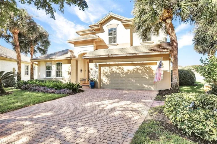Mediterranean / spanish-style home with a front lawn and a garage