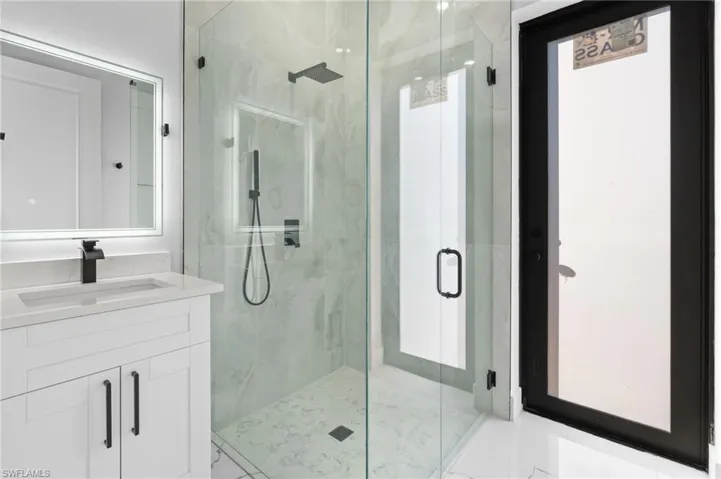 Full bathroom featuring vanity and a marble finish shower