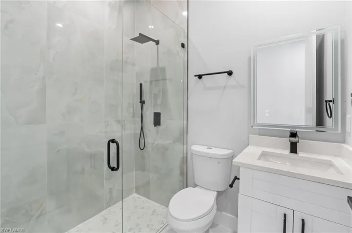 Full bath with a marble finish shower and vanity