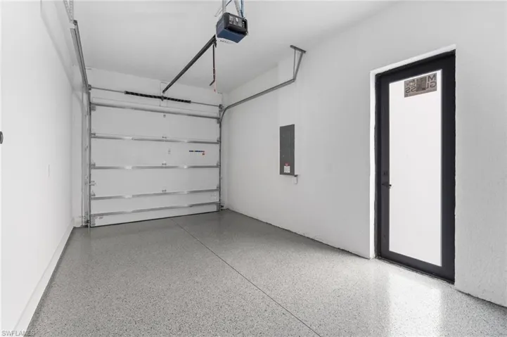 Garage featuring electric panel and a garage door opener