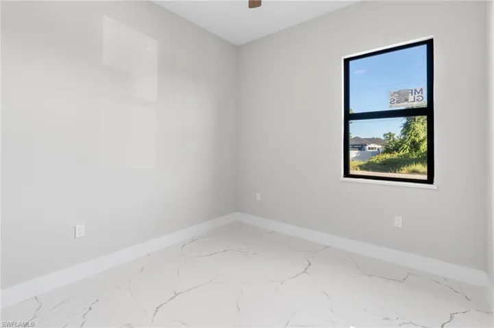 Unfurnished room featuring baseboards and marble finish flooring