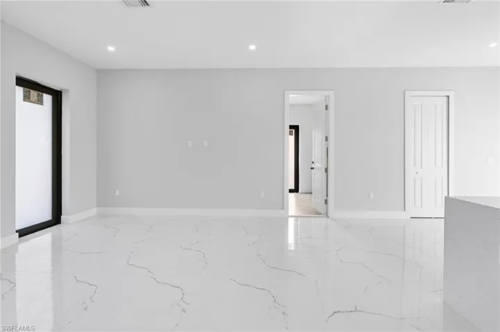 Unfurnished room featuring light marble finish flooring and recessed lighting