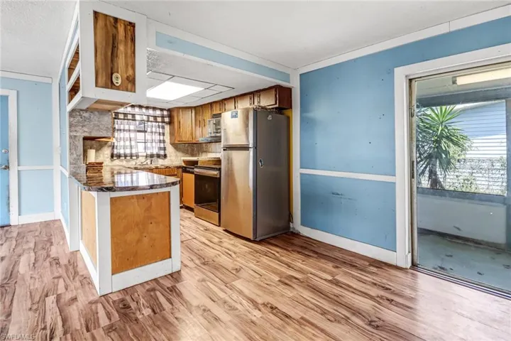 Kitchen featuring stainless steel appliances, tasteful backsplash, light wood-type flooring, and a healthy amount of sunlight