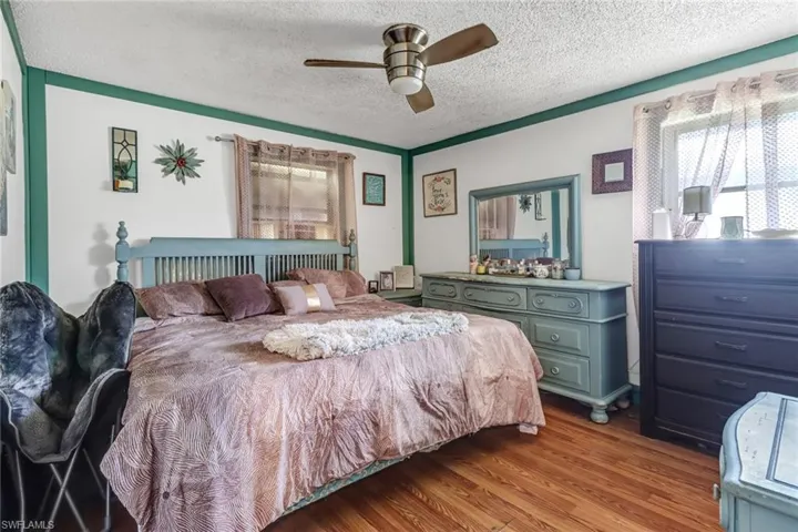 Bedroom featuring a textured ceiling, ceiling fan, and hardwood / wood-style floors