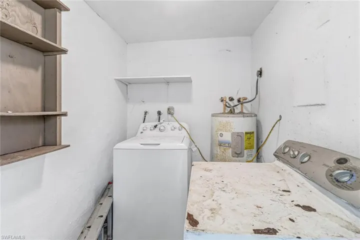 Clothes washing area featuring water heater and washer / clothes dryer