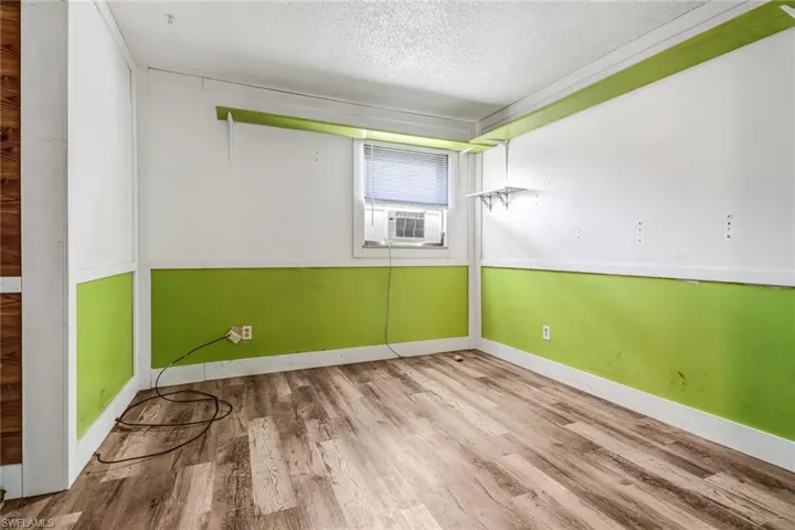 Spare room with a textured ceiling and hardwood / wood-style flooring
