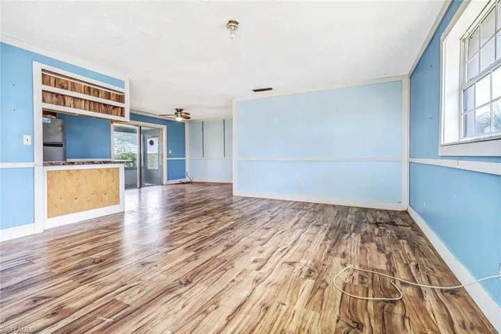 Unfurnished living room featuring a textured ceiling, ceiling fan, and hardwood / wood-style floors