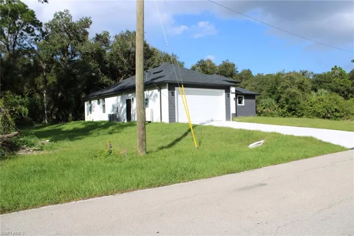 Single-story residence featuring a dual-tone exterior, dark shingle roof, two-car garage, and concrete driveway