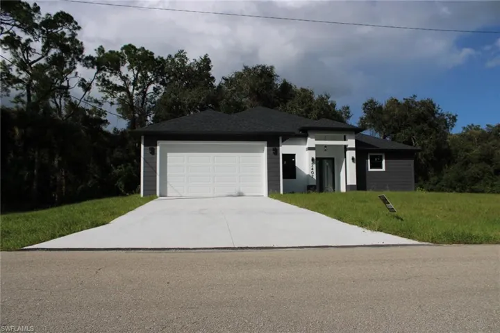 Single-story residence featuring horizontal lap siding, a high-contrast exterior color palette, an asphalt shingle roof, and a concrete driveway