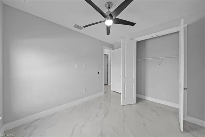 Unfurnished bedroom featuring ceiling fan and a closet