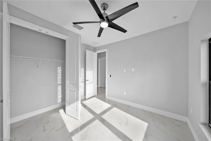 Unfurnished bedroom featuring ceiling fan and a closet