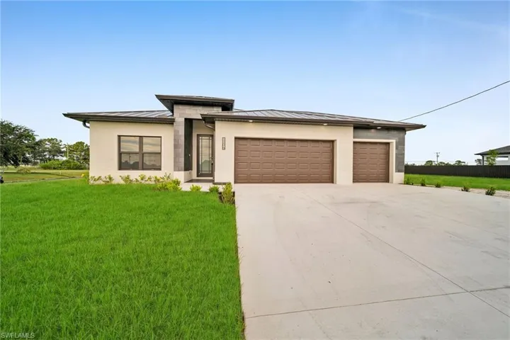 Prairie-style house featuring a front yard and a garage
