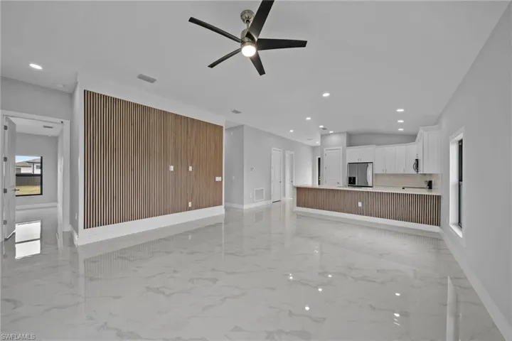 Unfurnished living room with ceiling fan and plenty of natural light