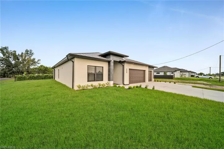 View of front of house with a garage and a front lawn