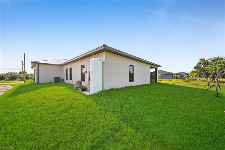 View of side of property featuring a yard and central air condition unit