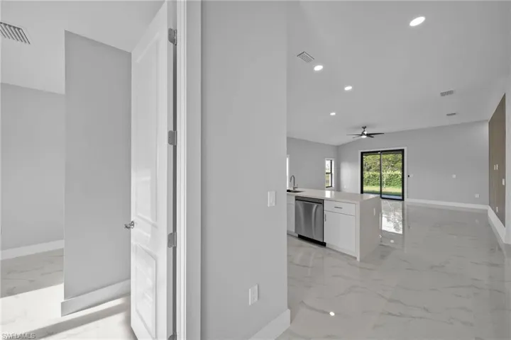 Kitchen featuring white cabinetry, dishwasher, ceiling fan, and sink